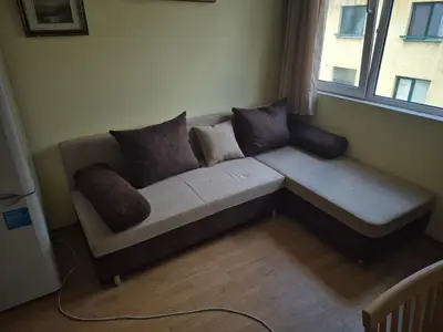 a couch sitting in a room with a window at 2 Rooms Apartment - Top Center of Burgas in Burgas City