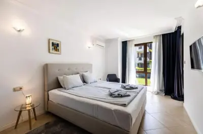 a bedroom with a bed and a large window at Oasis Beach Club - 