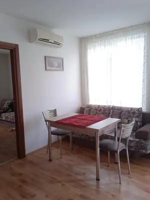 a living room with a table and chairs and a couch at Тристаен апартамент в Бяла комплекс Атлантик in Byala