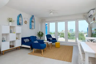 a living room with blue chairs and a table at Sirena Seaview Apartment - FREE PARKING in Varna City