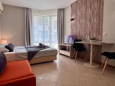 a bedroom with a bed and a desk and a window at Apartament Royal Sun Romantic - 5 min to the beach in Sunny Beach