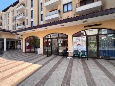 a building with glass doors and tables and chairs at Apartament Royal Sun Romantic - 5 min to the beach in Sunny Beach
