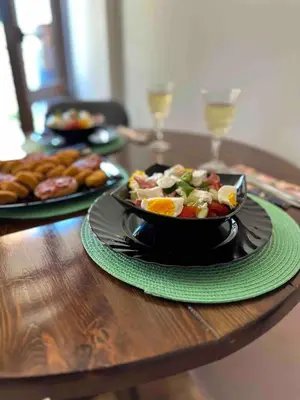 a table with a plate of food and wine glasses at Свети Влас комплекс Викторио in Burgas City