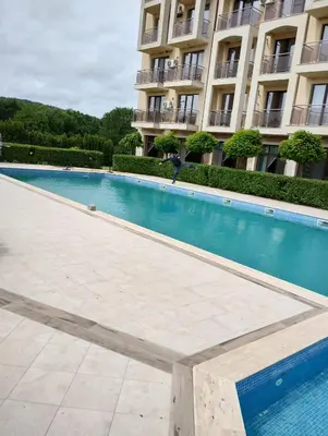 a swimming pool in front of a building at 2 Zimmerwohnung in Shkorpilovtsi