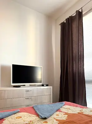 a bedroom with a tv on a dresser with a bed at Apartment 7 in Sozopol