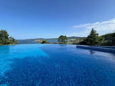 a large swimming pool with blue water at Saint Thomas Holiday Village Condo in Sozopol