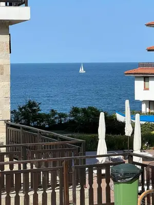 a view of the ocean with a sailboat in the distance at Saint Thomas Holiday Village Condo in Sozopol