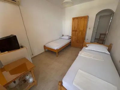 a small room with two beds and a television at Anastra in Pomorie