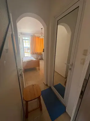 a hallway with a mirror and a chair and a bed at Anastra in Pomorie