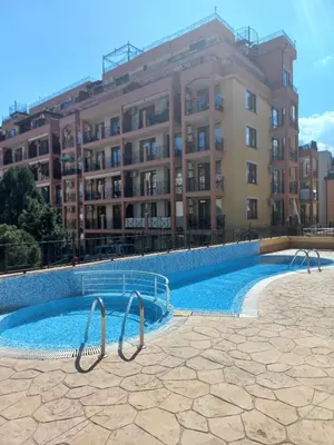 a swimming pool in front of a large building at Cozy studio 150m from the beach in Sveti Vlas