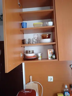 a cupboard with plates and dishes in it at Cozy studio 150m from the beach in Sveti Vlas
