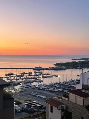 a marina with boats in the water at sunset at Sea view apartment in Sozopol