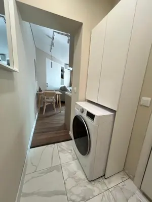 a washing machine in a laundry room with a table at Lazur Beach Residence - 10min walk to beach in Burgas City