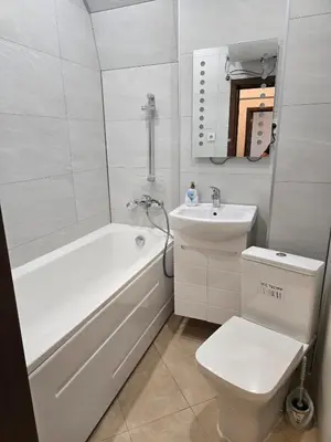 a bathroom with a tub and a toilet and a sink at Super Lovely Apartment in Burgas City
