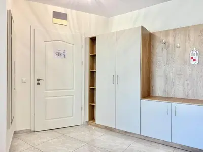 a kitchen with white cabinets and a white door at Sea View Allure Studio with Balcony in Primorsko
