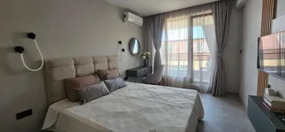 a bedroom with a large bed and a window at Ika Delux in Burgas City