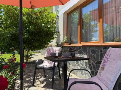 a table and chairs under an umbrella on a patio at Sea Garden Escape - Byala in Byala