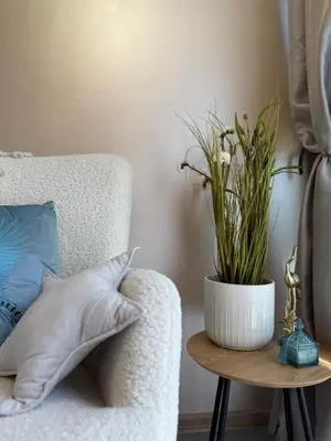 a white couch with a vase of flowers on a table at Sea Garden Escape - Byala in Byala