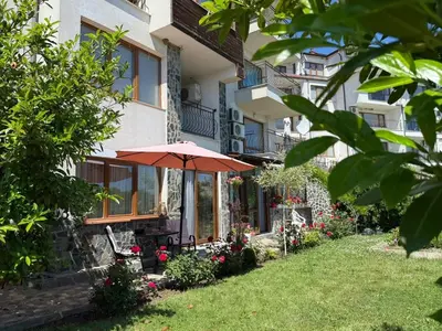 a house with an umbrella in the yard at Sea Garden Escape - Byala in Byala