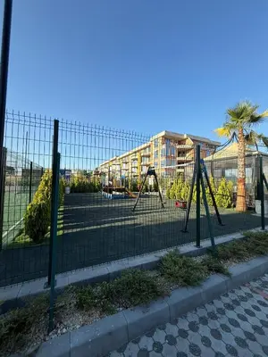 a tennis court with swings on a tennis court at Сарафово Family in Burgas City