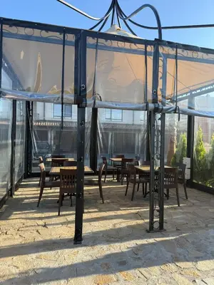 a tent with tables and chairs on a patio at Сарафово Family in Burgas City