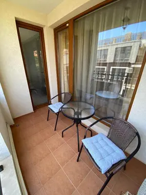 a balcony with two chairs and a table and a window at Marina Park OLIWIA in Sveti Vlas