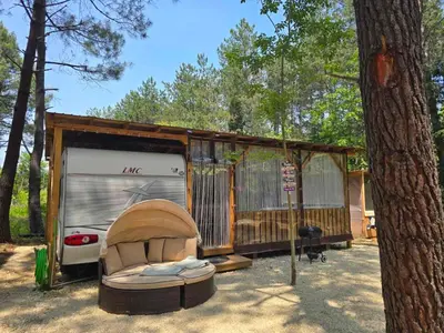 a rv parked in front of a tree at Каравана Coco Bongo in Chernomorets