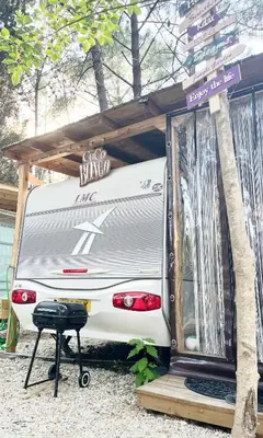 a white camper parked under a wooden structure at Каравана Coco Bongo in Chernomorets