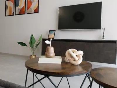a living room with a table with a tv on the wall at Ika Apartment Central in Burgas City
