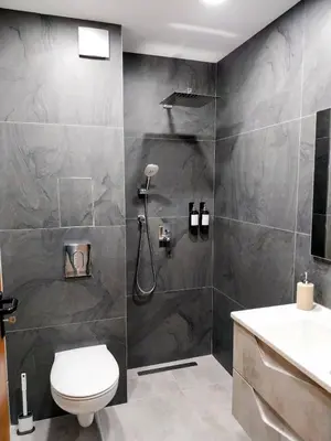 a bathroom with a shower and a toilet and a sink at Ika Apartment Central in Burgas City