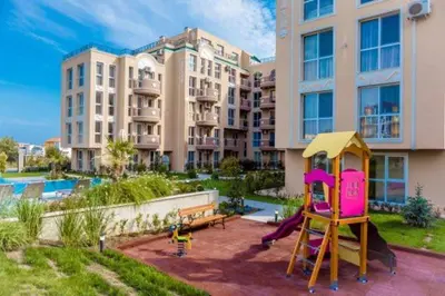 a playground in front of a large apartment building at Marea Garden Apartment Ravda in Ravda