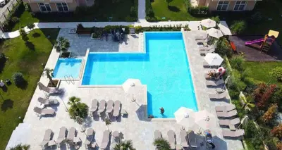an overhead view of a swimming pool with chairs and umbrellas at Marea Garden Apartment Ravda in Ravda