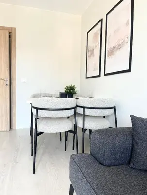 a living room with a table and chairs and a couch at Marea Garden Apartment Ravda in Ravda