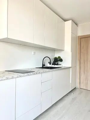 a white kitchen with white cabinets and a sink at Marea Garden Apartment Ravda in Ravda
