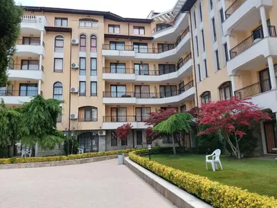 a white chair in front of a building at 2 Room Apartment with Poolview Royal Sun in Sunny Beach