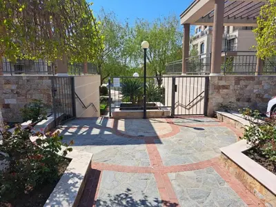 a courtyard with a gate and a brick building at Sorrento Sole Mare Sveti Vlas in Sveti Vlas