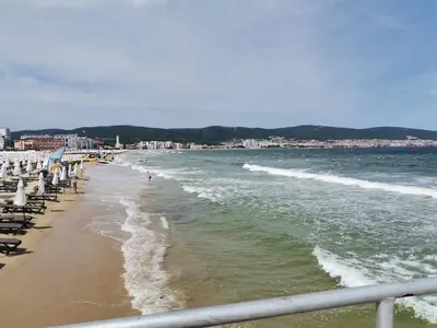 a beach with chairs and people in the water at Family Studio flat in Tŭnkovo