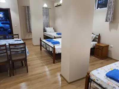 a room with two beds and a table and chairs at Студио Морски бриз in Pomorie