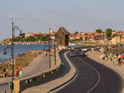 a road with cars on it next to a beach at VIGO Nessebar in Nesebar