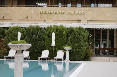 a pool with chairs and a fountain in front of a hotel at Аpartment in the Garden of Eden in Sveti Vlas