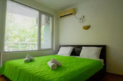 a bedroom with a green bed with a window at NeV Getaway for 2 in Burgas City