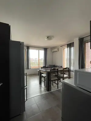 a kitchen and living room with a table and chairs at Adagio Sarafovo in Burgas City