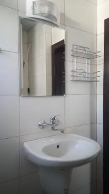 a bathroom with a white sink and a mirror at Adagio Sarafovo in Burgas City