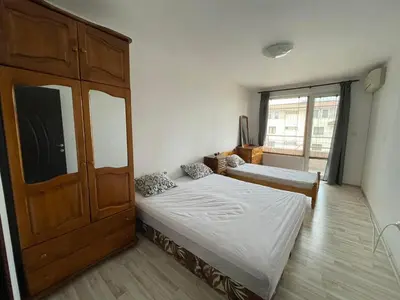 a bedroom with two beds and a large cabinet at Adagio Sarafovo in Burgas City