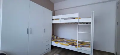 a white bedroom with a bunk bed and white cabinets at Divine place Pomorie in Pomorie