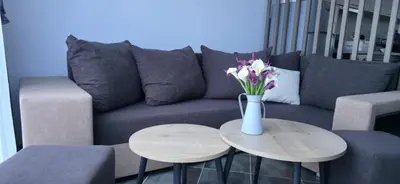 a blue couch with a vase of flowers on a table at Divine place Pomorie in Pomorie