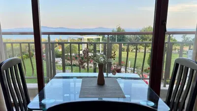 a glass table with a vase on top of a balcony at Апартамент Панорама, двустаен, малък, първа линия, гледка море, DIAMOND BEACH, Сарафово in Burgas City