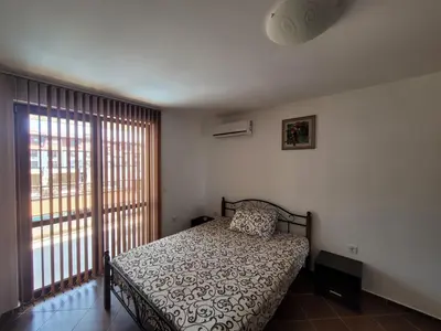 a bedroom with a bed and a large window at Famagusta Antoniya in Aheloy