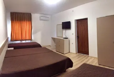 a hotel room with two beds and a window at Вила НАДЕЖДА in Byala