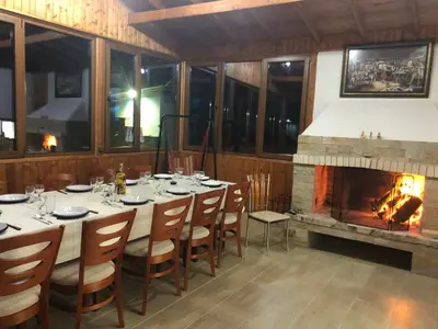 a dining room with a table and a fireplace at Вила НАДЕЖДА in Byala
